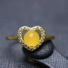 A 15-year-old store has a heart-shaped ring with a white jade crystal bead, amber and copper setting details Picture